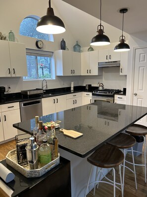 Renovated kitchen with black granite counter tops, lots of light