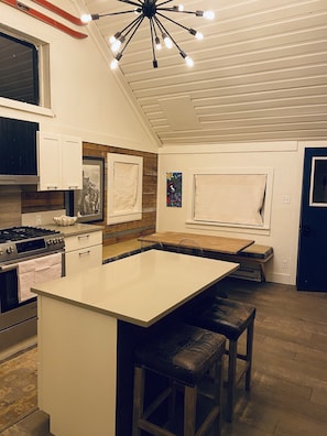 Kitchen with large island, dining booth and Bosch appliances.