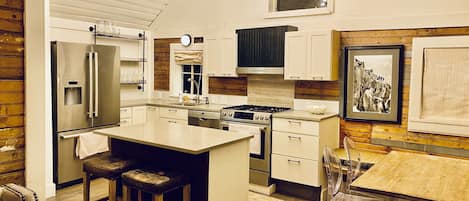 Great kitchen with quartz counters, new appliances and charming chandelier.