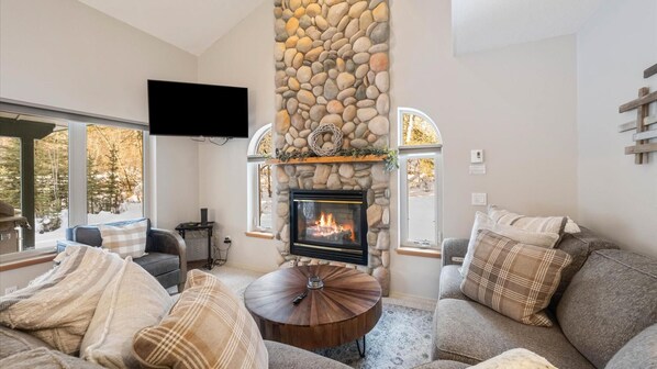 Cozy up by the fireplace after a long day of adventures with HDTV with streaming capabilities and luxury sofa.