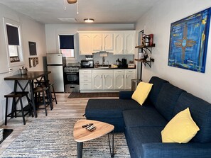 Living room with smart TV, kitchen and dining table.  