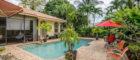 Salt water pool and fenced property with plenty of palms and bushes for privacy