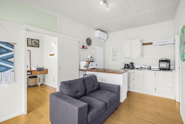 Photo of the lounge, kitchenette to the right of the couch.