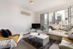 A living with a 2-seater sofa bed and an L shaped sofa chaise set.