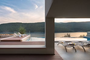 Sunbathing area near private pool with deck chairs of Labin seafront Luxury Villa for vacation and rent.