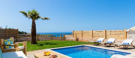 The pool terrace is equipped with patio furniture.