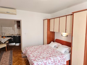 double bed, dining area and kitchenette - all in the same room