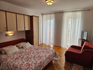double bed, dining area and kitchenette - all in the same room