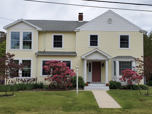 Front of Yellow House featuring the beautifully landscaped yard!