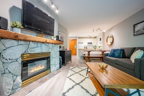 Living Room - Stylish and modern decor, cozy fireplace, satellite/streaming on TV, two pull-out couches