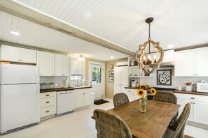 Full Kitchen with Farmhouse Sink and Wood Counters - This St. Simons vacation rental features a clean, functional kitchen with butcher block counters, a farmhouse sink, and space to cook, gather, and come back for seconds.