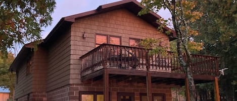 Front of home facing lake. Back deck with table on upper level.