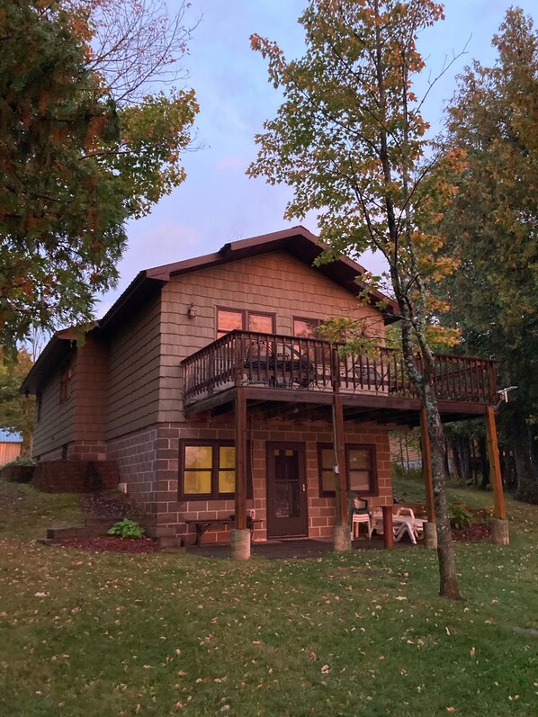 Front of home facing lake. Back deck with table on upper level.