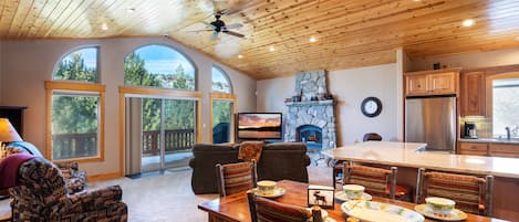 Hillside Mountain Creek Haven - a SkyRun North Tahoe Property - Living Room (main level) - Open, grand floor plan with access to kitchen and dining area, 1/2 bath and master bedroom w/direct access to spacious deck - stunning views!