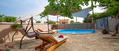 Chaises longues à l\'ombre au bord de la piscine