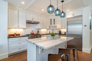 Natural stone surfaces, crisp clean lines and stunning lighting for the perfect kitchen creation space