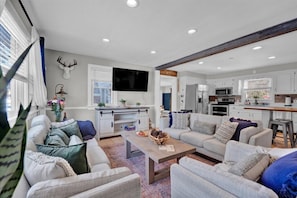 Spacious open-concept living room with ample seating and a Smart TV—perfect for relaxing and gathering with loved ones!