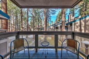 Sliding glass doors in main living area open up to a breakfast balcony with seating for 4 overlooking the wooded grounds of Lakeland Village