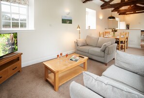 The open-plan living style connects the sitting room, dining area and kitchen