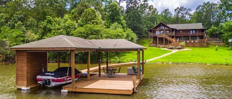 large grassy backyard with stone pathway from main home to boathouse .and lake