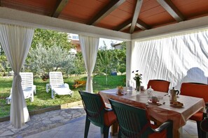 The terrace with awning, table, and 4 chairs, ideal for having your morning coffee in peace with a garden view.