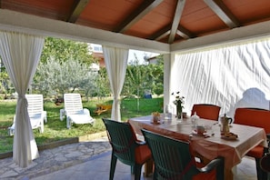 The terrace with awning, table, and 4 chairs, ideal for having your morning coffee in peace with a garden view.
