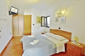 The bedroom with double bed (160x200), two bedside tables with night lamps, a wardrobe, and flat-screen satellite TV.