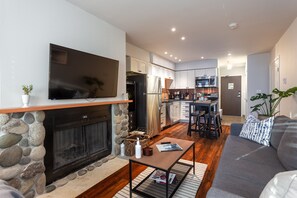 Wood fire place, kitchen and flat screen TV with Amazon Firestick with Netlix