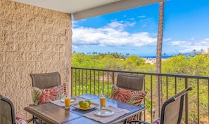 Balcony with table and chairs plus nice view of the ocean