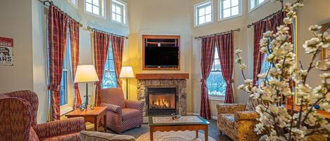 Living area with gas fireplace, sofa bed, and large smart LCD TV