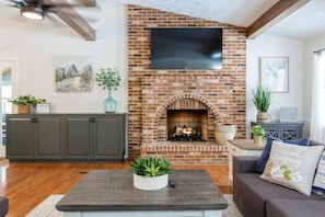 Cozy around the gorgeous gas fireplace in spacious living room with sectional sofa and flat screen TV