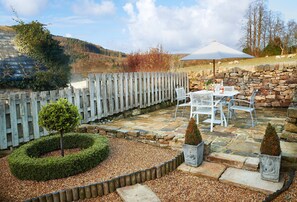 Enclosed rear garden with garden furniture, perfect for al fresco dining looking out over stunning views