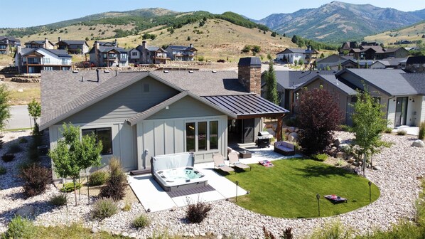 View from the back of the house showing private hot tub, patio, and yard.