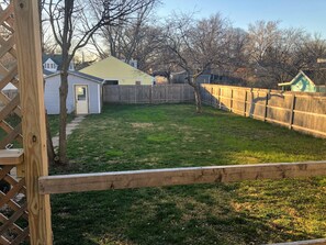 Fenced-in backyard and view to 1-car garage. 