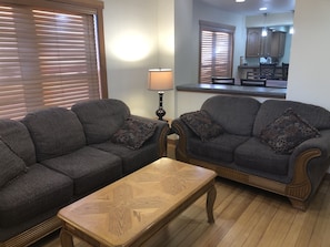 Living room with semi-open floor plan provides sightlines to kitchen/dining room