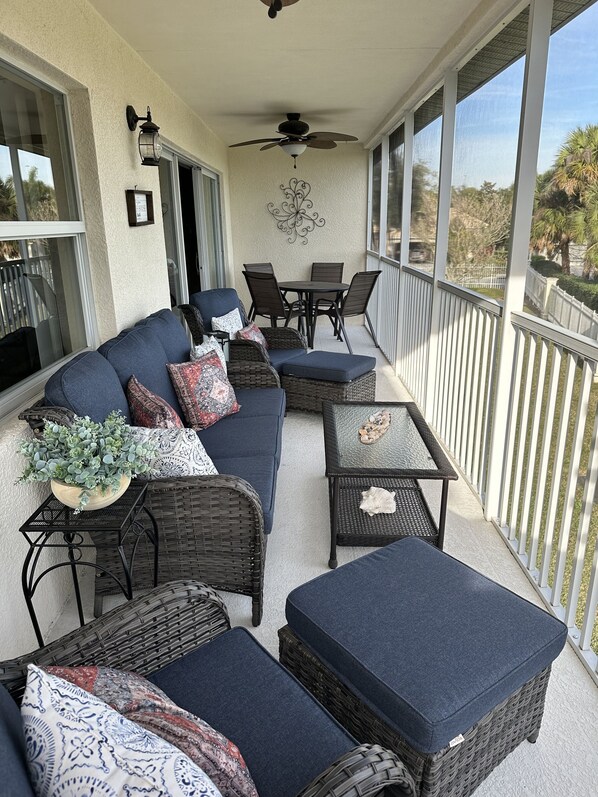 Screened in Lanai with couch, chairs, 4 top table overlooking the golf course