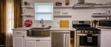Kitchen has stainless steel appliances and farm sink