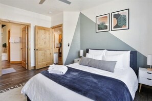 First bedroom features queen size Nectar mattress, TV, and en suite bath