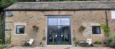 Exterior of the 2 cottages at Woodcock Farm, terrace in front and shared garden