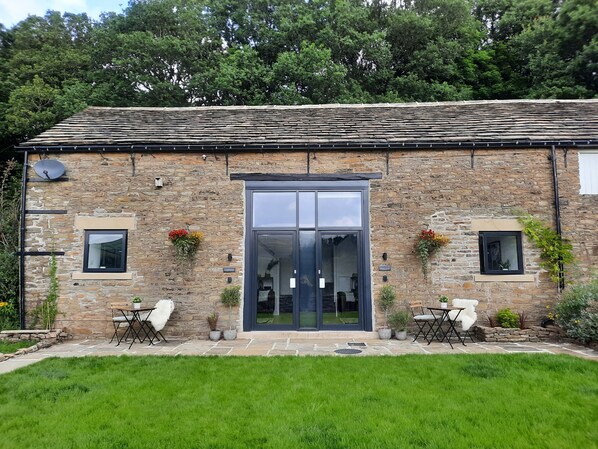 Exterior of the 2 cottages at Woodcock Farm, terrace in front and shared garden