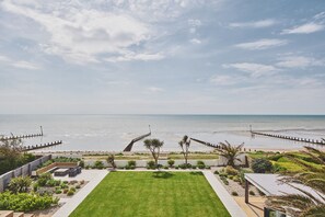 Stunning view from the large balcony to the garden, beach and out to sea