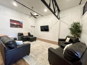 65" TV surrounded by comfortable seating