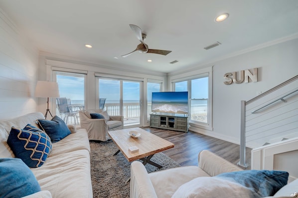 The welcoming living room boasts wrap-around windows offering stunning views of the Gulf of Mexico.