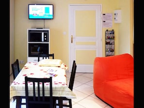 The living room, dining table and one single sofa bed