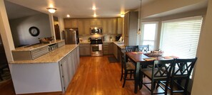 Large kitchen with granite countertops and gas cooktop stove.