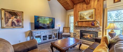 Grand living area with vaulted ceilings, large flatscreen TV gas burning fireplace.