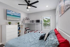 Elegant bedroom with king sized bed, single bunkbed, , drawers for storage and smart TV. Ideal room for a group of friends or a family with kids.