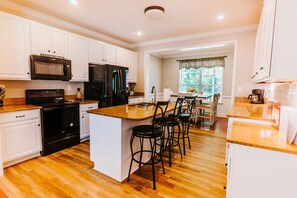 Fully stocked kitchen with dishes, glasses, silverware, pots and pans