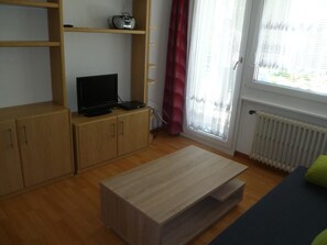 Salle de séjour avec porte donnant sur le balcon