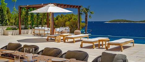 Luxusvilla mit Meerblick in Kroatien mit privatem Pool, umgeben von Liegestühlen und Sonnenterrasse für den Urlaub
